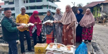 Masdar Tambusai (pakai rompi) Ketua PW GEMMA Sumut saat menyerahkan bantuan atas peristiwa kebakaran di Persulukan Babussalam Desa Besilam Kabupaten Langkat